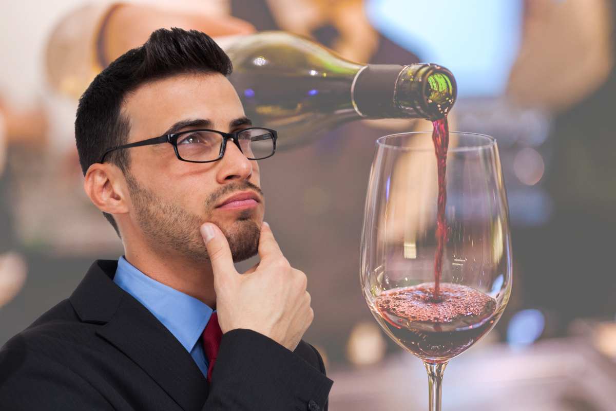uomo pensieroso e versare il vino nel bicchiere